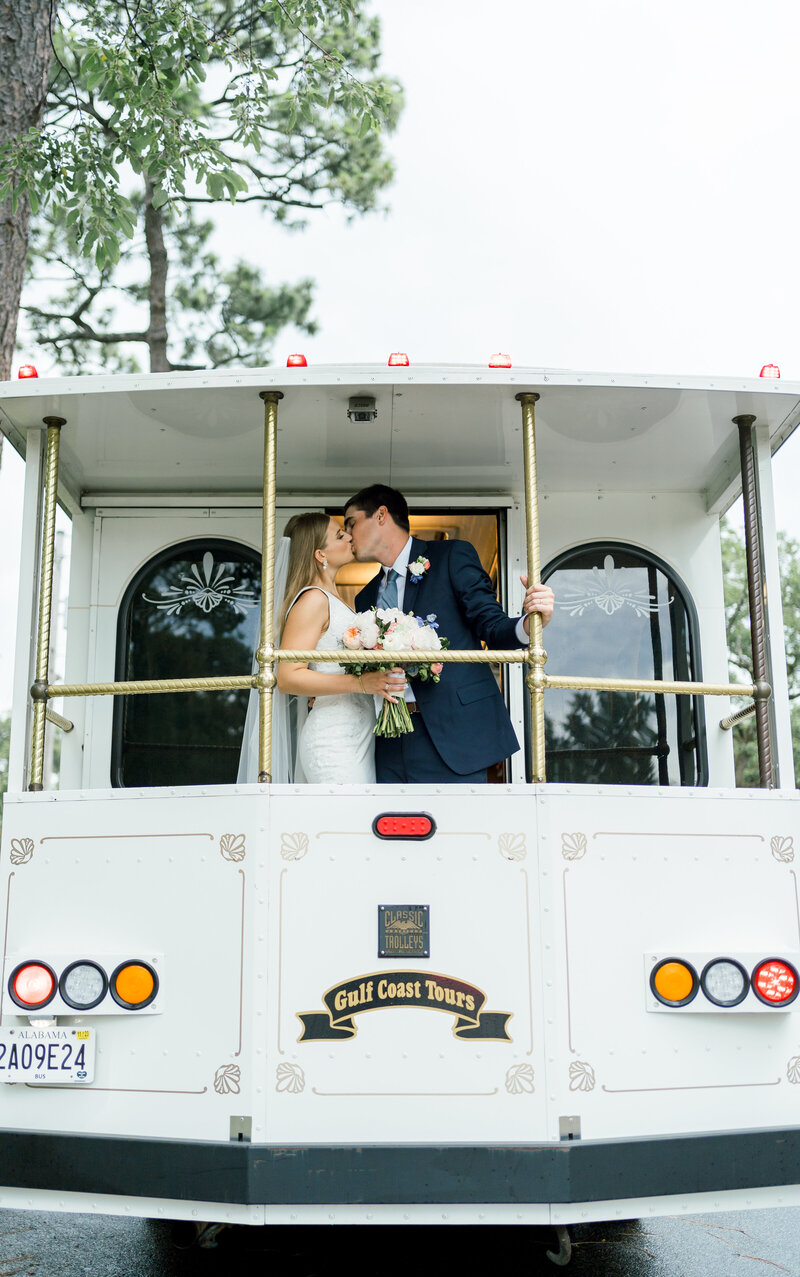 bride and groom kissing on a trolley