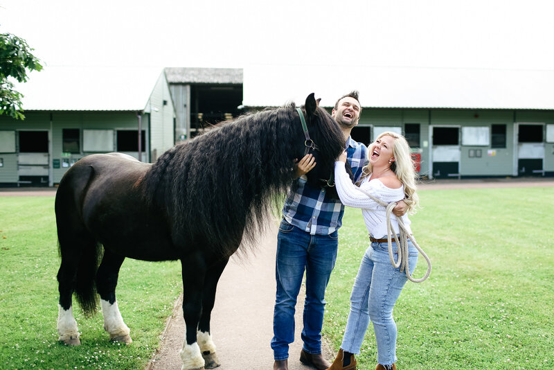 couple-laughing-with-horse-at-engagement-shoot-in-buckinghamshire-by-leslie-choucard-photography