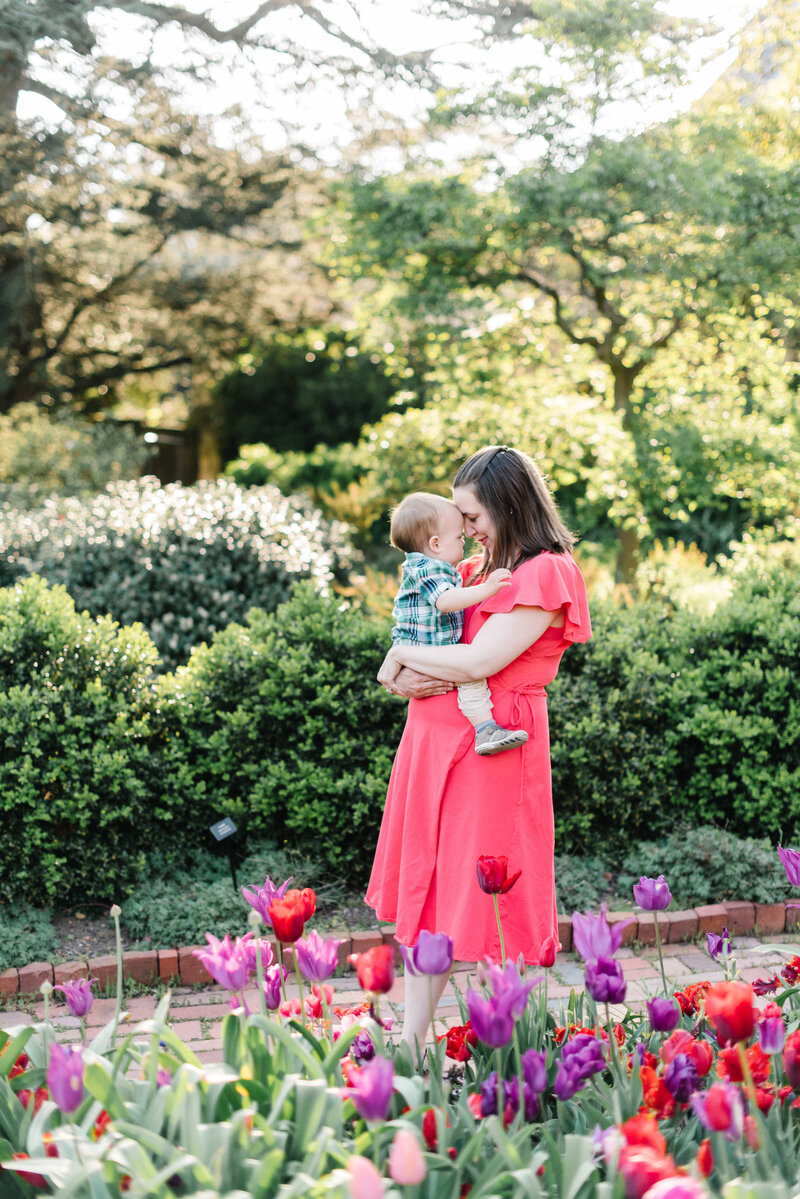 Mom in red dress holding a baby in a garden - Washington DC Family Photographer