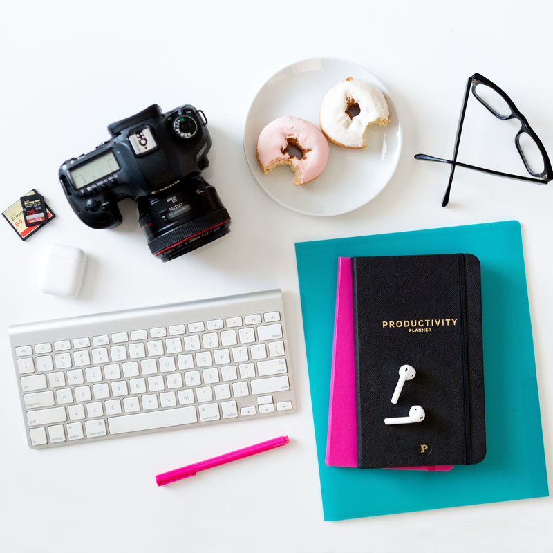Keyboard, notebooks, donuts and professional camera