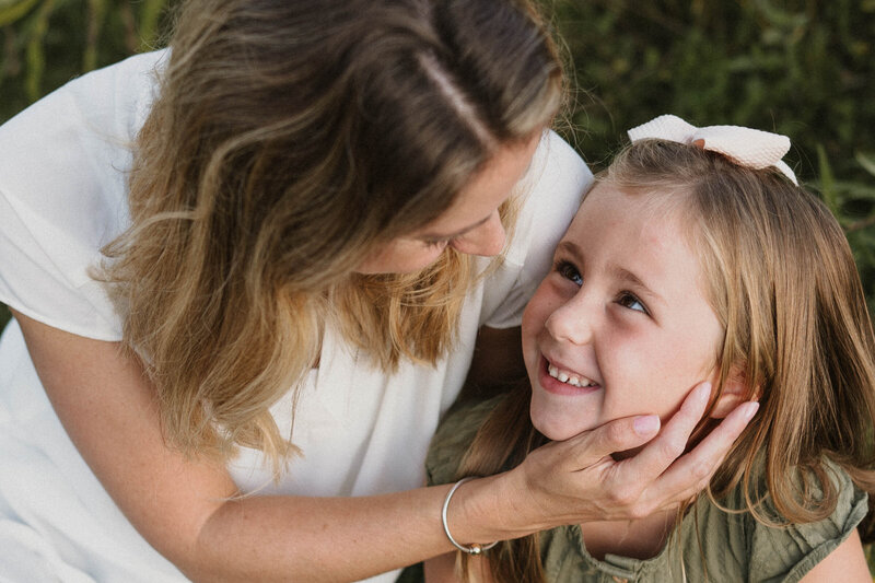 mom holding daughter's face
