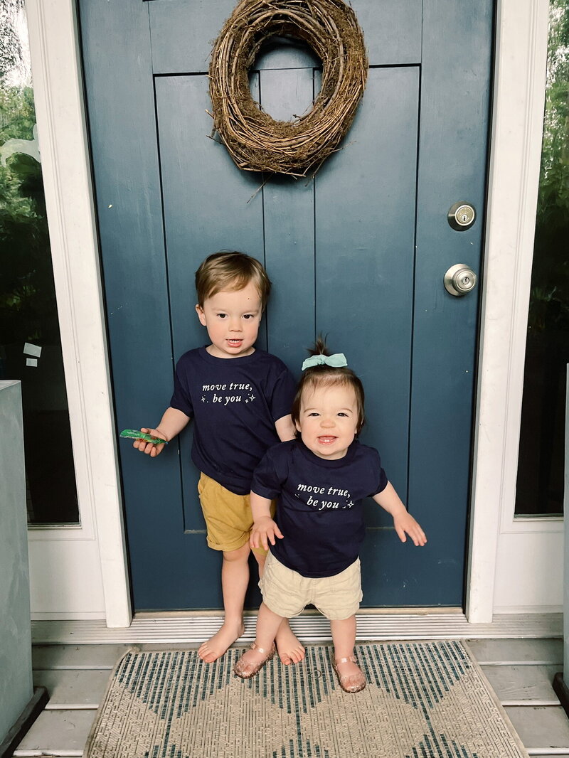 Toddlers smiling and wearing matching shirts with True40 logo