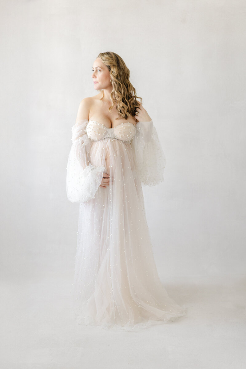 Tampa designer maternity gown portrait in natural light at Tampa studio