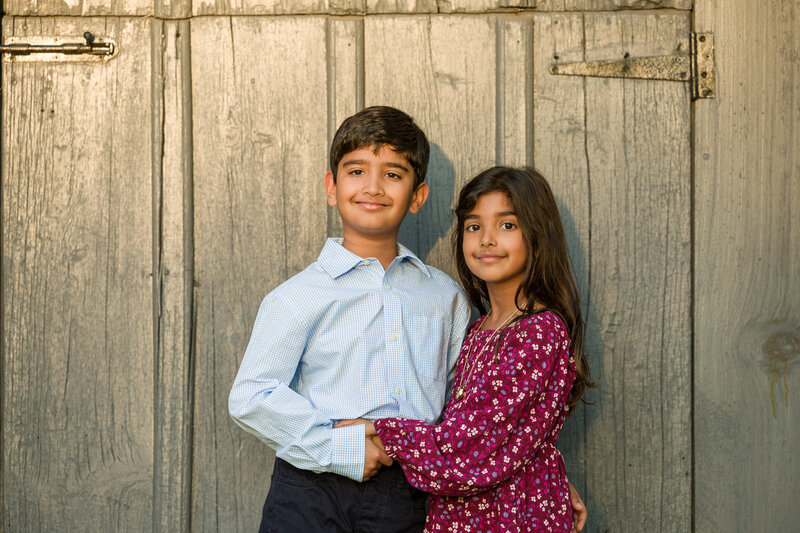 Two children posing for the camera with classic smiles, perfectly capturing the joy of a spring or autumn mini session in Valley Forge.