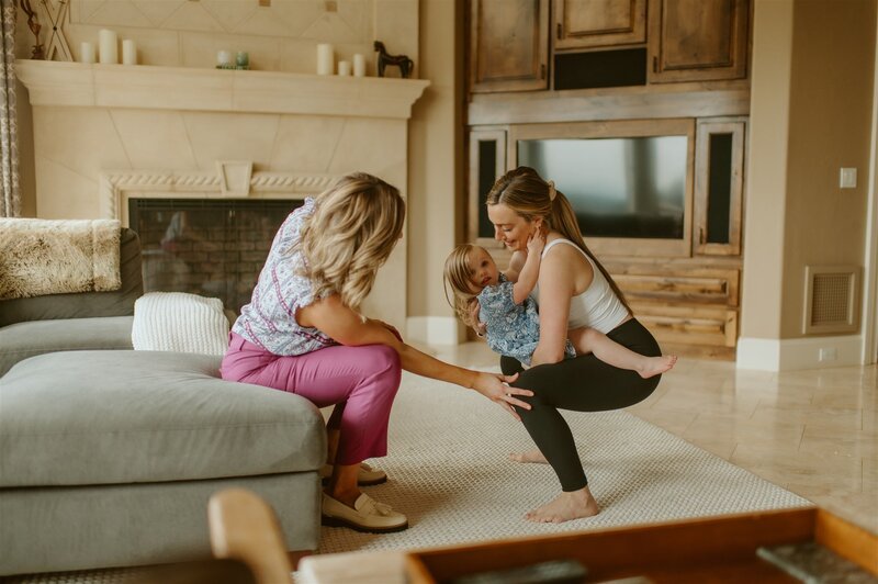 Dr Gwen works with a client holding her toddler during an in home concierge physical therapy session pelvic floor rehab. 