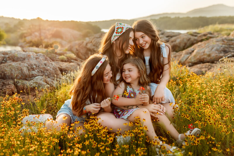 Overland Park Photographers capture sweet moment with mom and her three daughters in a flower field during sunset family session.