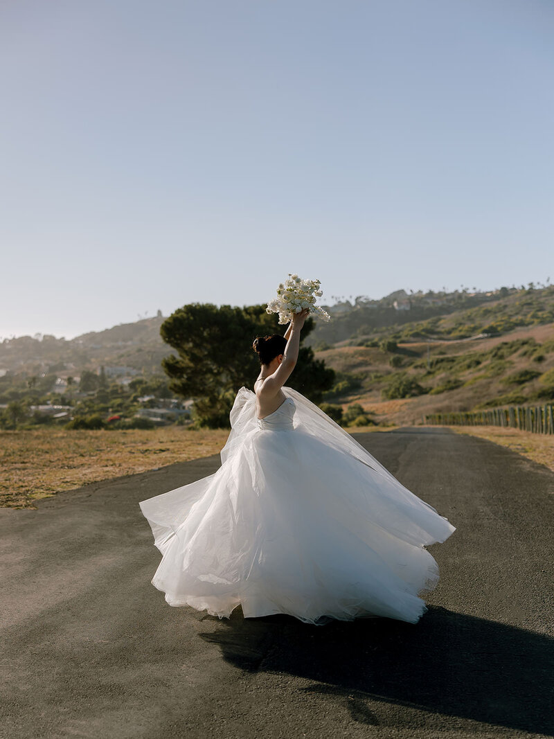 Bride dances with bouquet in air