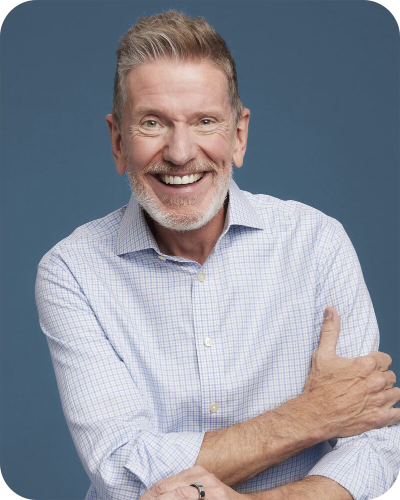 Michael Hyatt smiling in a professional headshot, wearing a dark blazer and light dress shirt, with a blurred studio background.