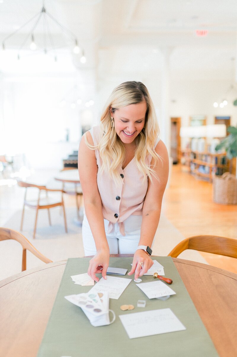 Stationery Designer in Virginia arranging wedding stationery flatlay