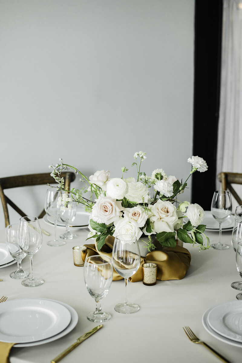 Floral arrangement and place settings at wedding reception table