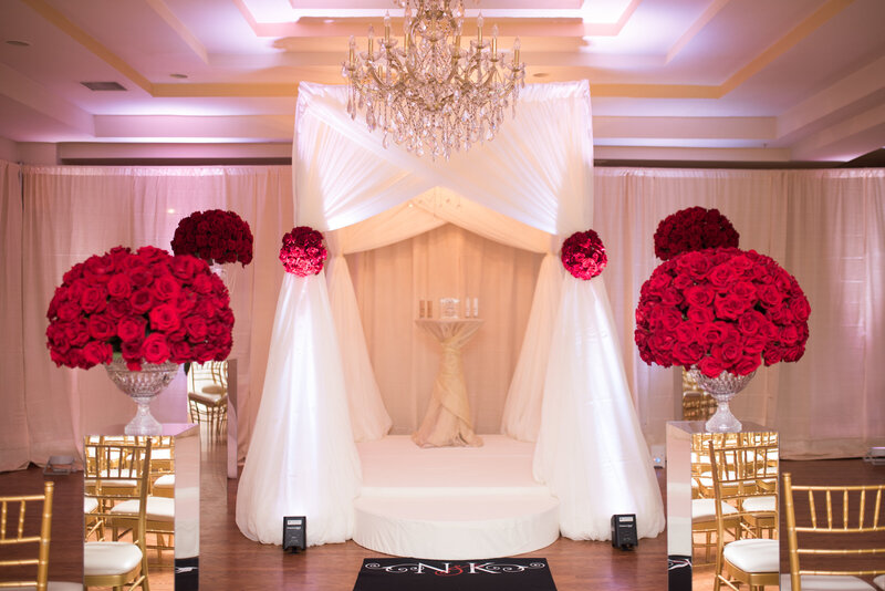Luxury wedding ivory and red ceremony decor.  Featuring red roses, draping and custom aisle runner at The Villa in Calverton, MD