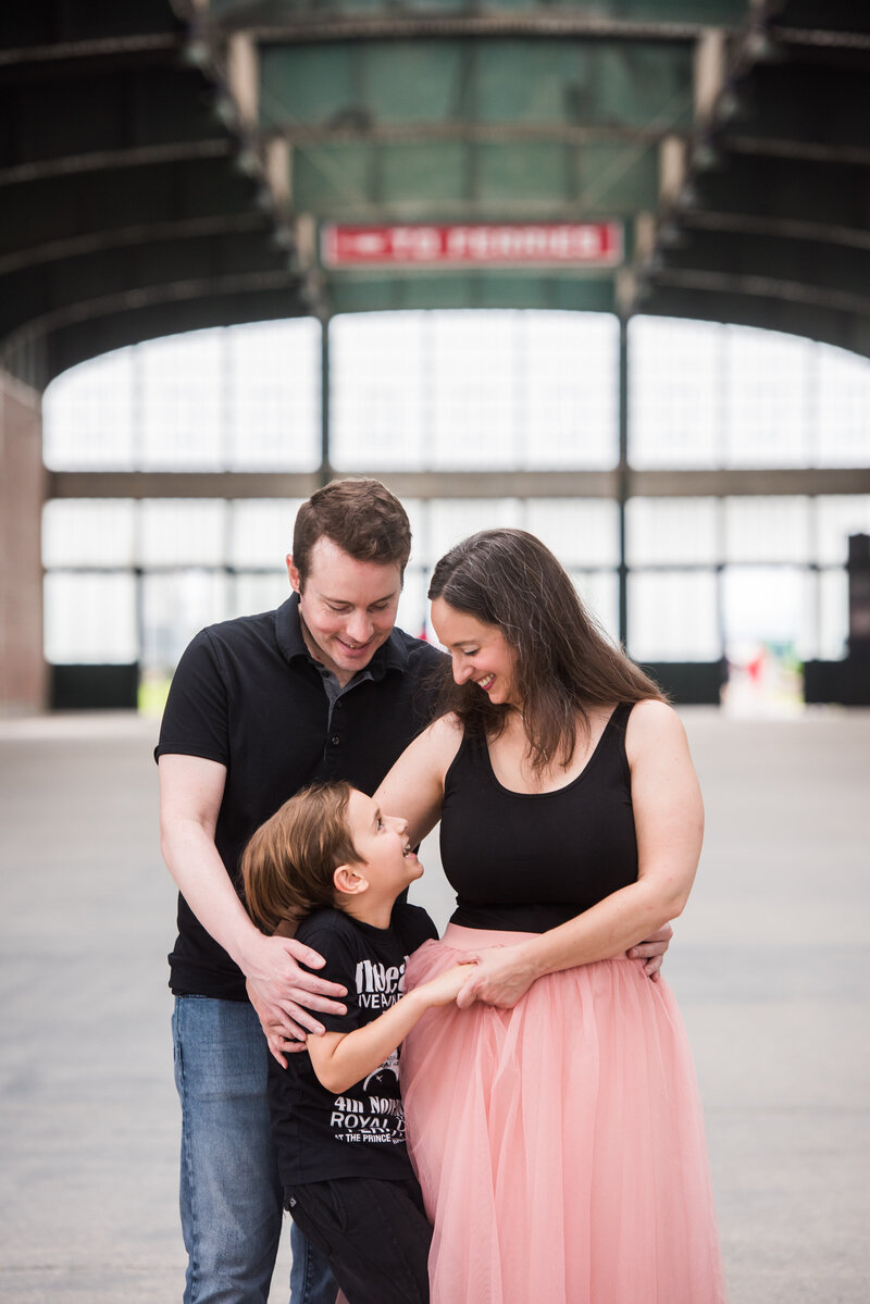 Two parents smiling as they look down at their child