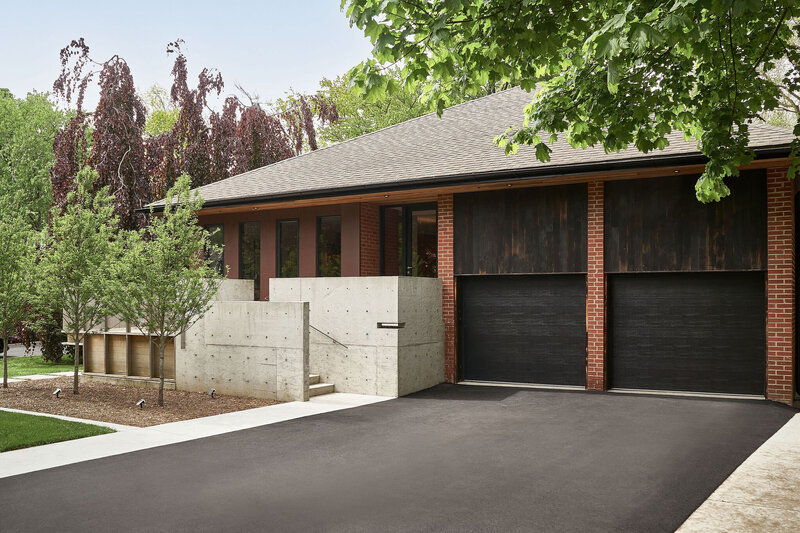 Shot of the Valentine HSE house with red brick, black accents and driveway
