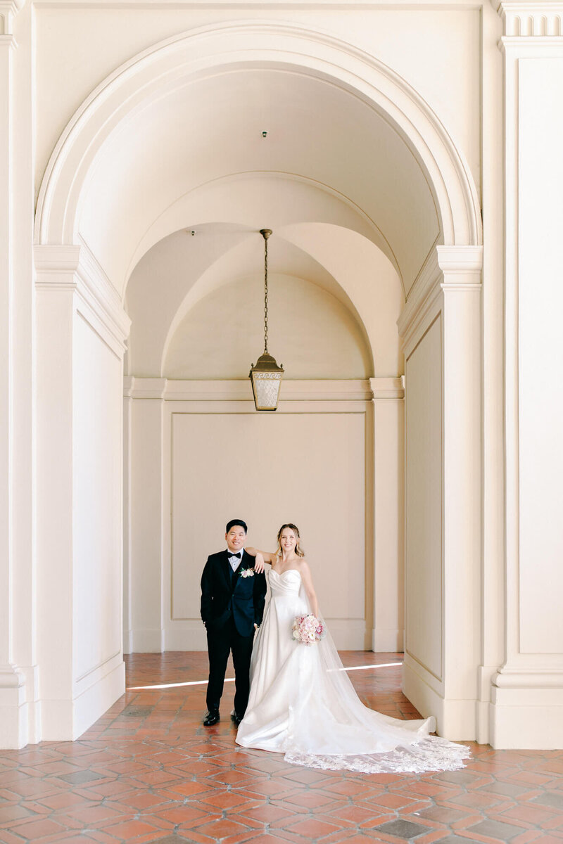 wedding photography of bride and groom in pasadena city hall underneath an arch