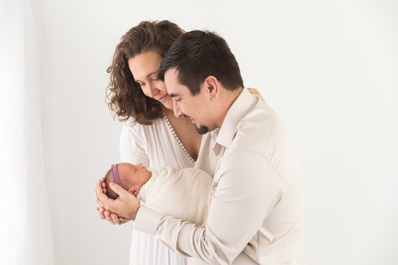 Parents looking at baby in studio by Baltimore Newborn Photographer