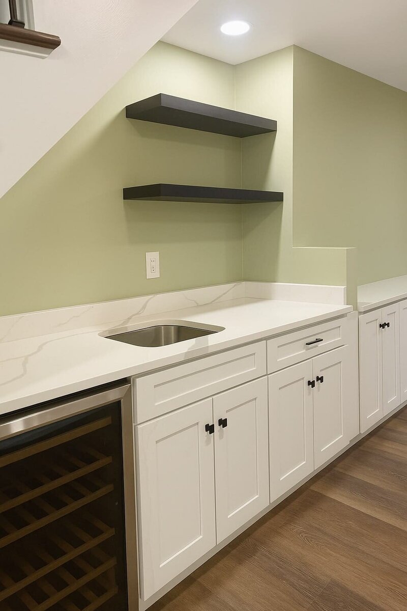 Modern basement remodel featuring built in kitchen with wine cooler, elegant quartz countertops, and custom white cabinetry.