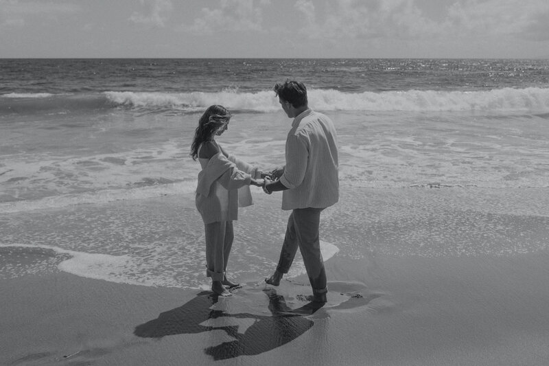 Newport beach engagement session, couple plays in the sand. 