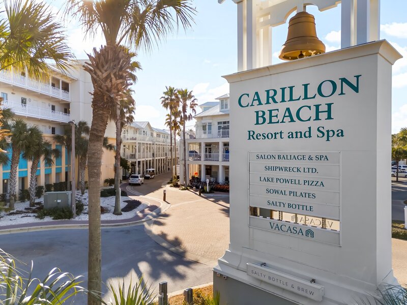 Entrance sign for Carillon Beach Resort and Spa surrounded by palm trees in Panama City Beach, FL.
