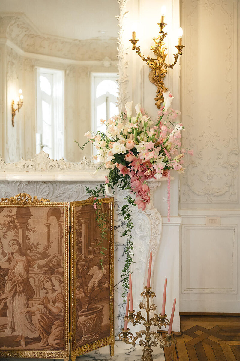 Romantic wedding fireplace with white, gold, and pink florals and candles at a Maryland venue; Klover Beauty provided bridal hair and makeup for this event.