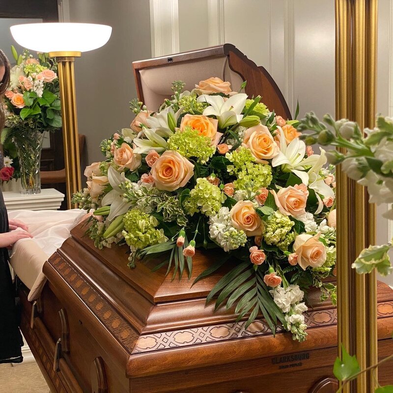 white lilies peach roses green hydrangea funeral casket flowers at White Pine Funeral Flowers 