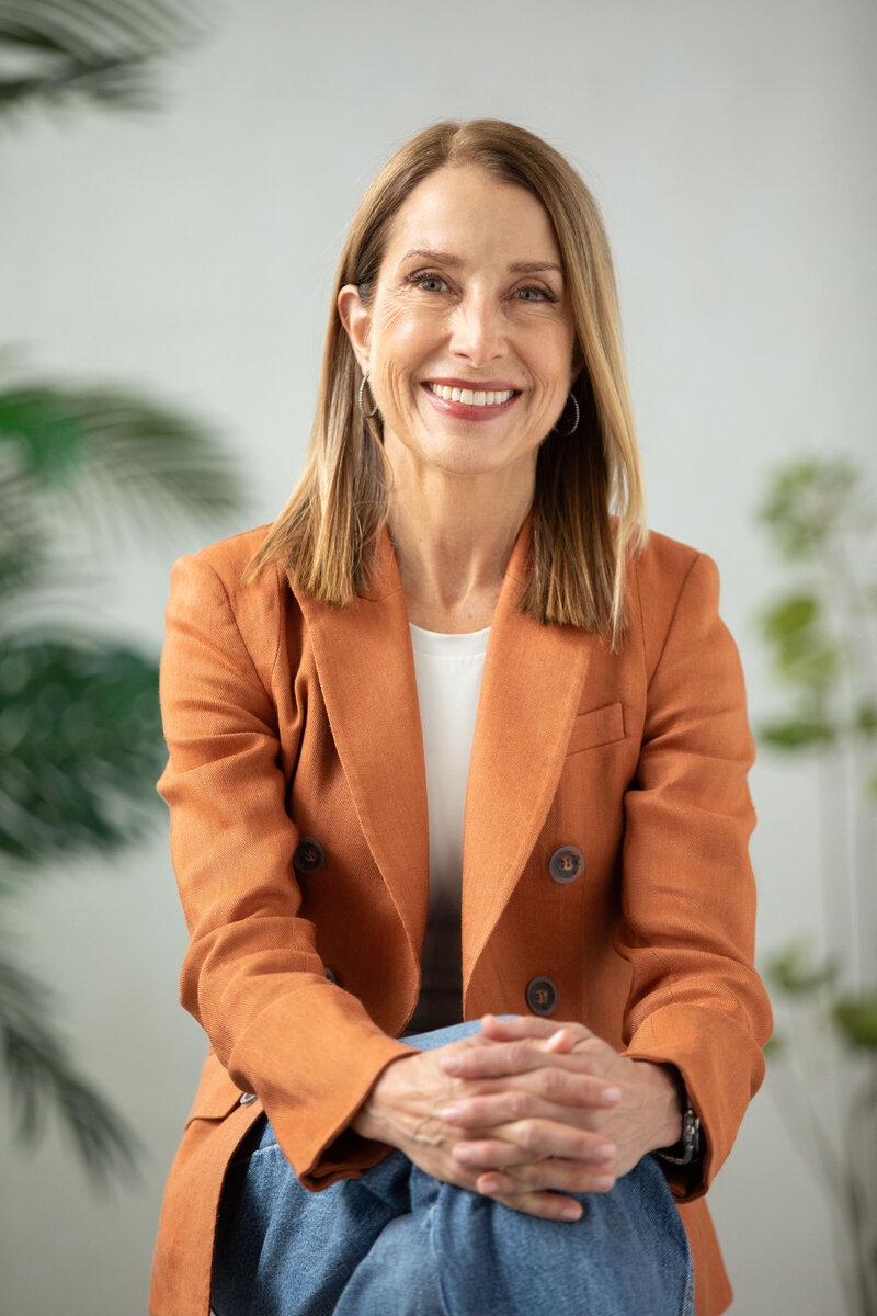 A confident woman, smiling, and conveying poise and professionalism