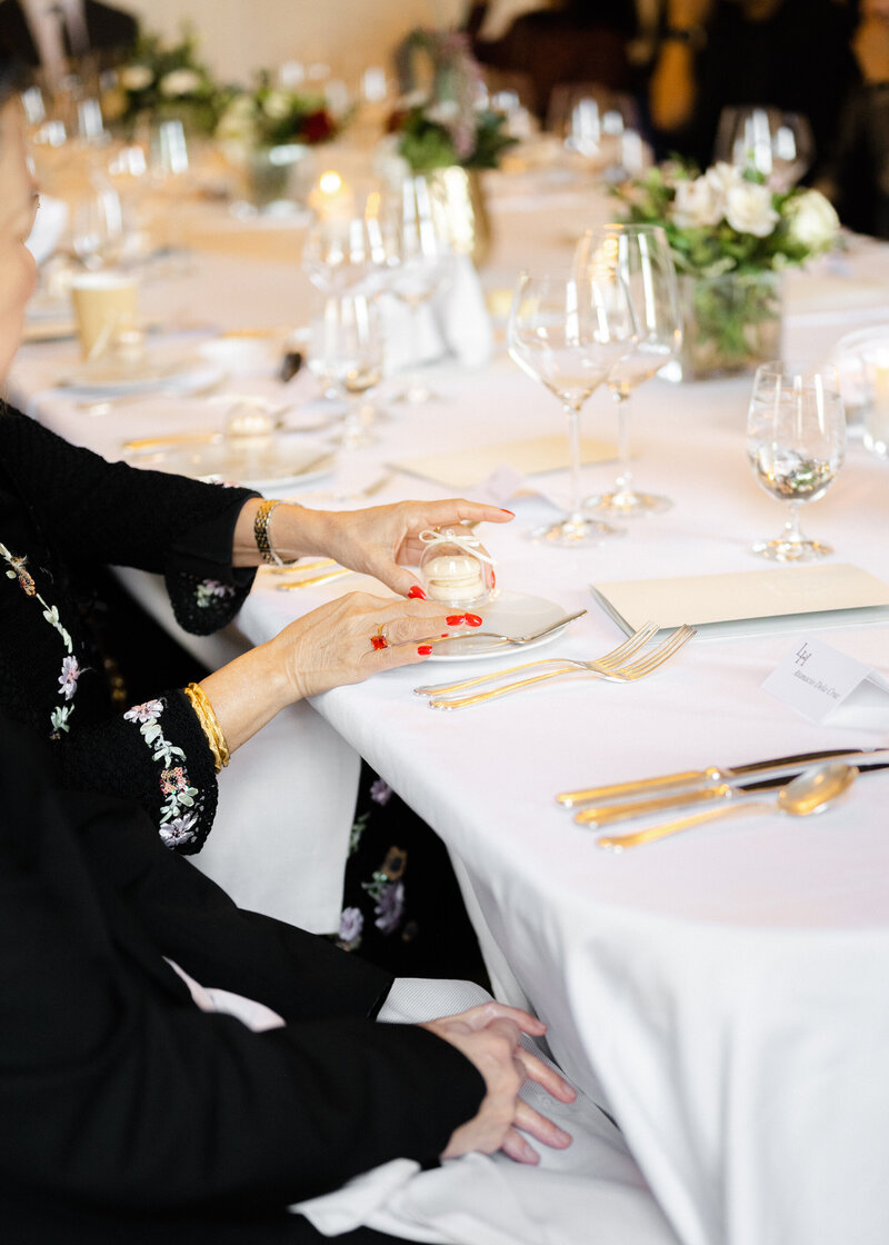 Woman holding macaron during an anniversary dinner