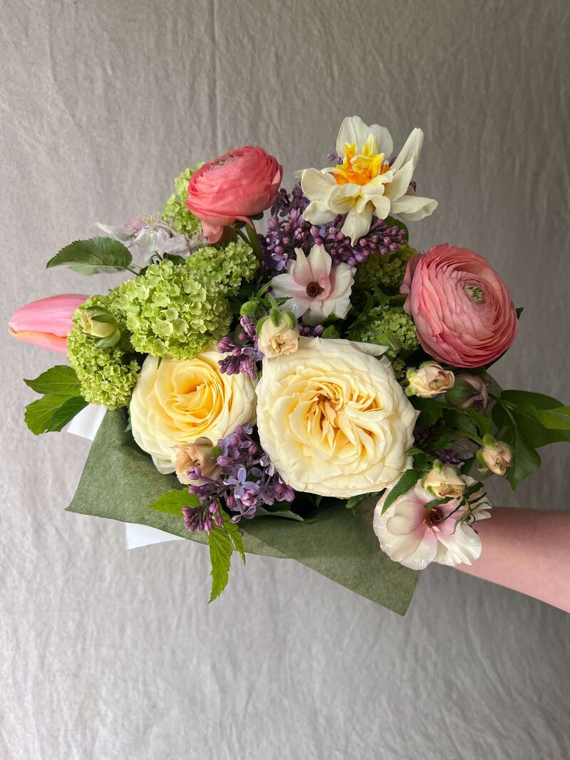 A hand tied spring flower market bouquet representing Mother's day offerings by Wild Child Flower Co in Eugene.