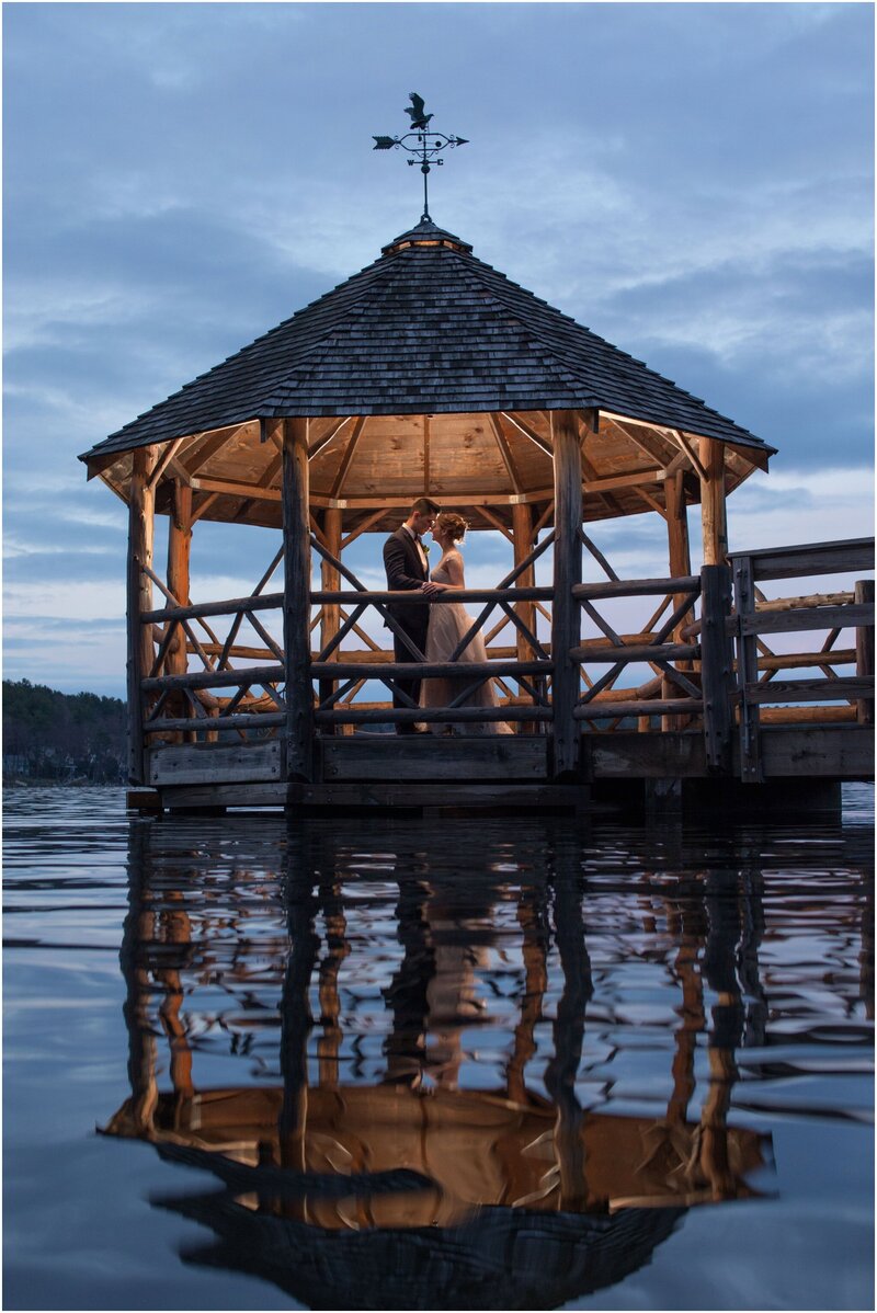 Bride and groom in gazebo over water