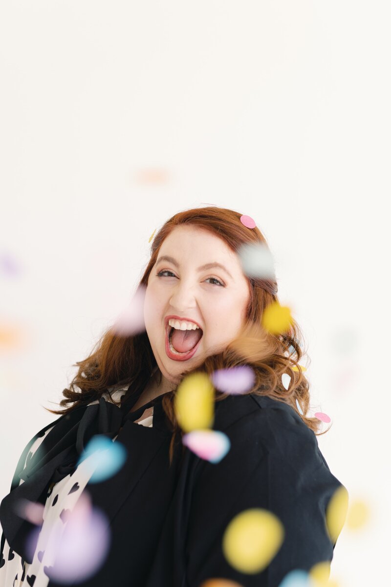 woman with big smile and confetti falling around her