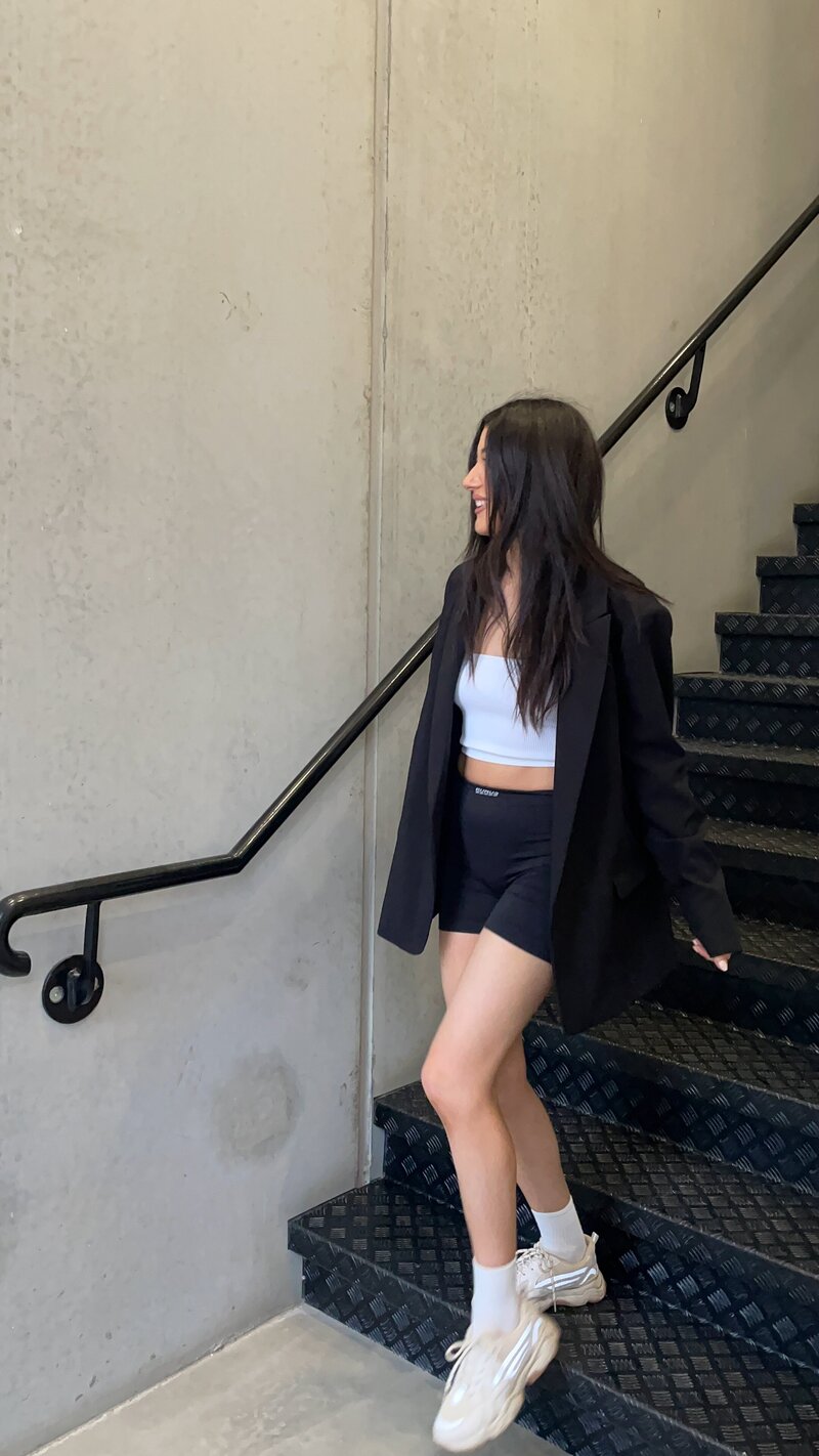 Woman walking down industrial stairs in black and white active wear