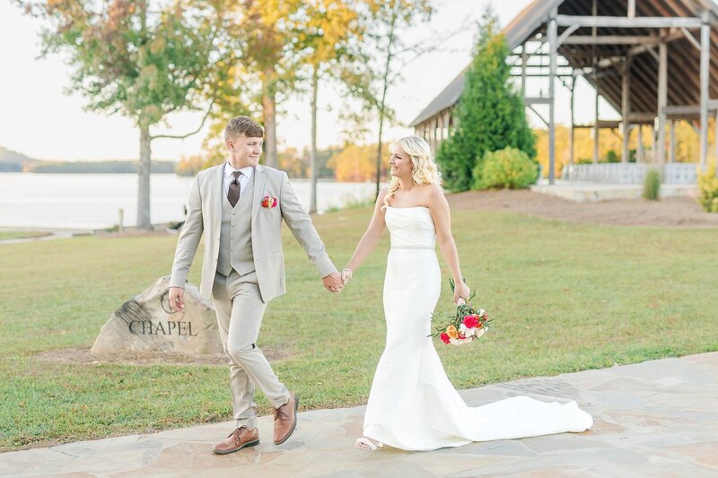 Bride and groom walking in front of New Water Farms open air chapel | Wedding Photography
