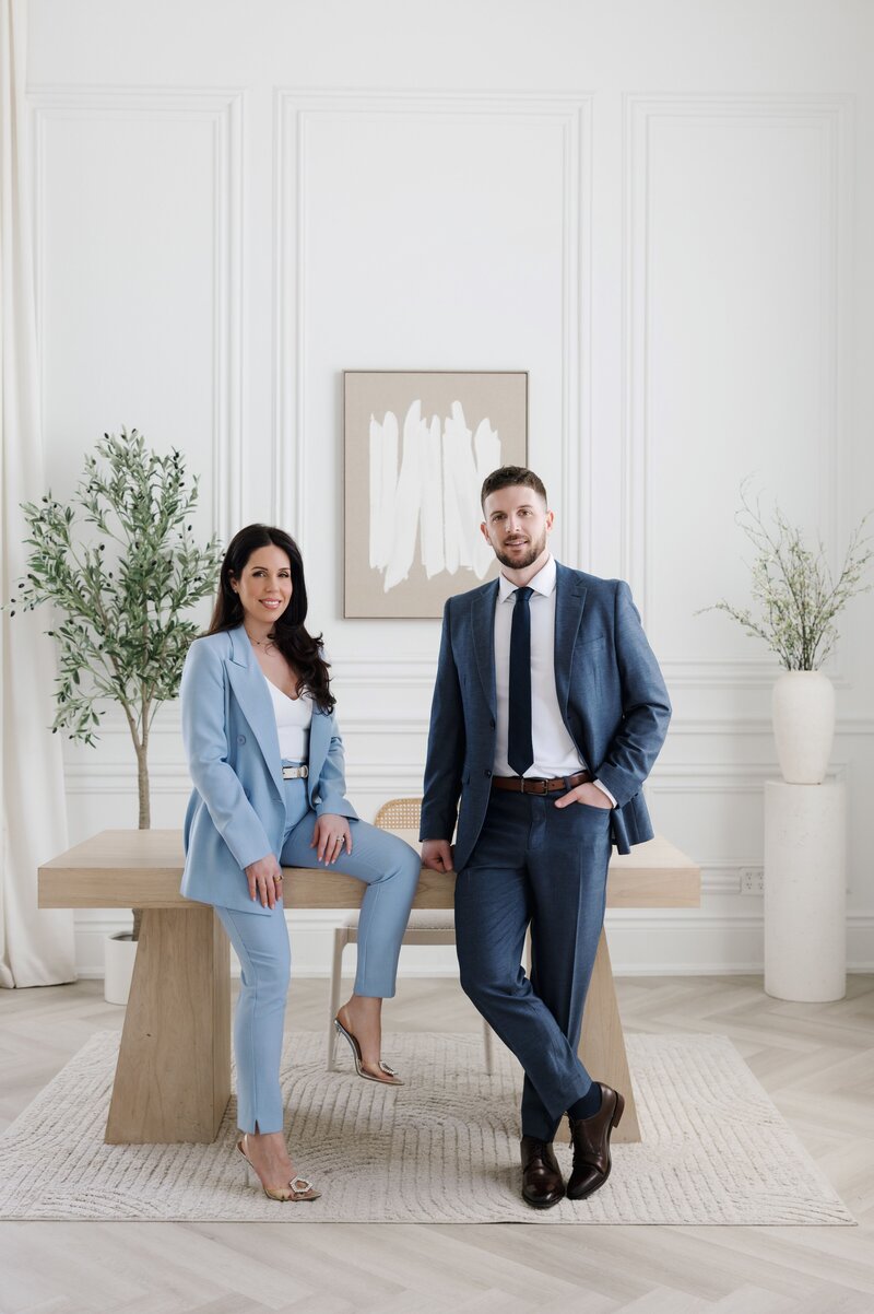 Steven and Caroline in suits smiling at camera