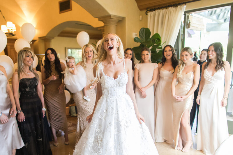 joyful bride laughing with wedding party