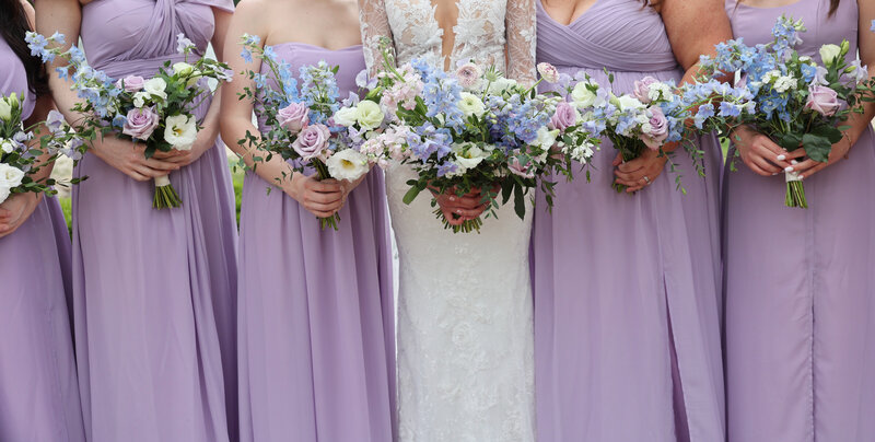 Bridal party hold spring flowers at Rumbling Bald on Lake Lure