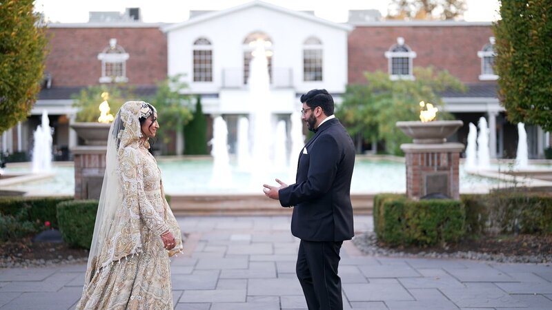 Amal & Ali embrace against the backdrop of the beautiful fountain rockleigh event center  in New Jersey