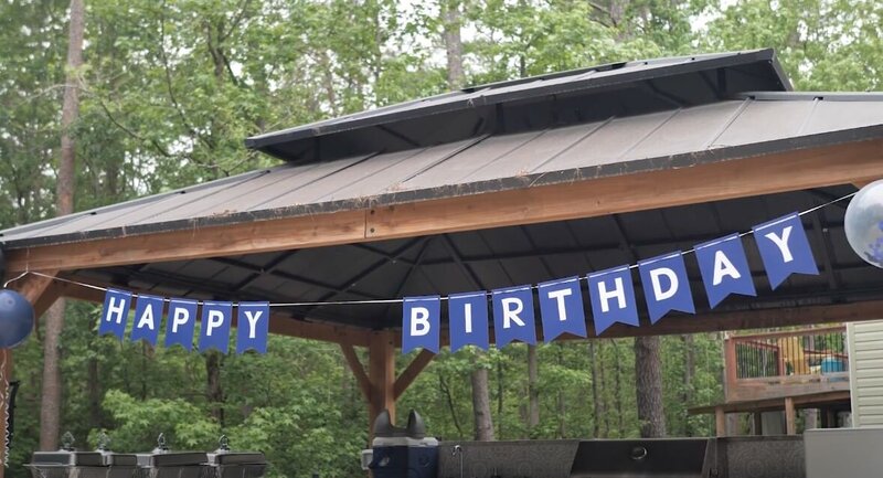 a happy birthday sign hanging in a gazebo 