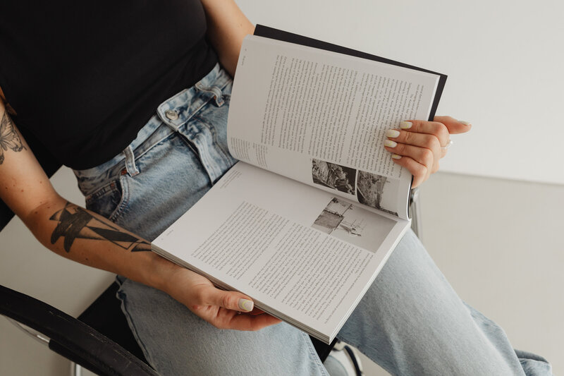 kaboompics_woman-in-light-colored-jeans-with-books-28227