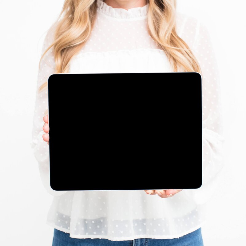 woman with long blond hair holding an ipad  out in front of her