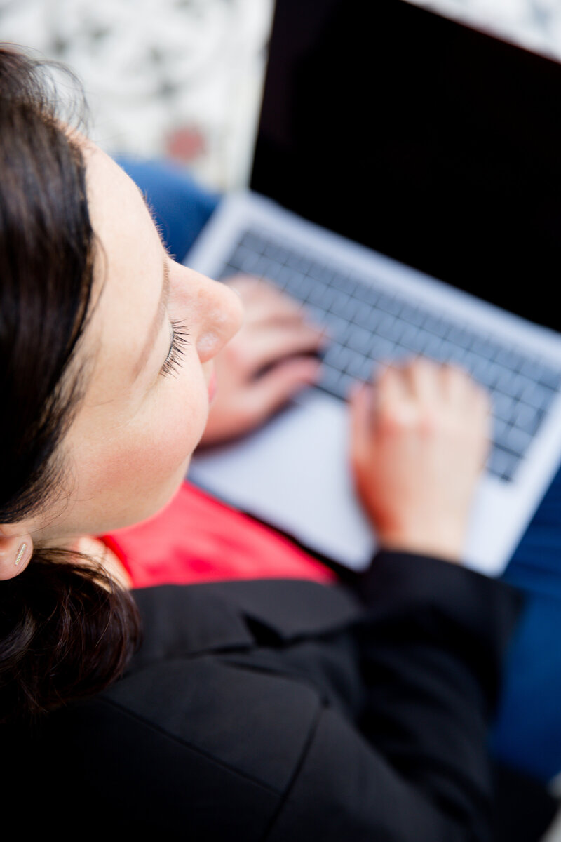 Person typing on a laptop, viewed from above, deeply immersed in academic research.