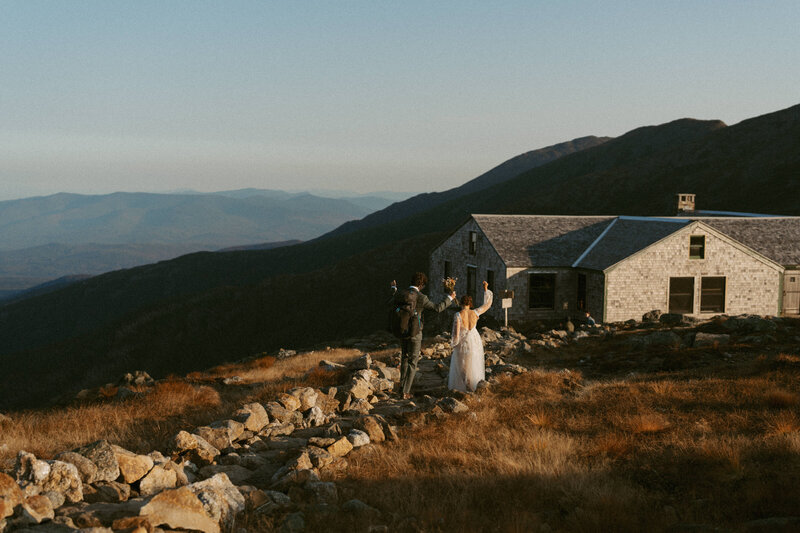 Bride and groom celebrating their elopement at the AMC Lakes of the Clouds Hut in the White Mountains, New Hampshire.