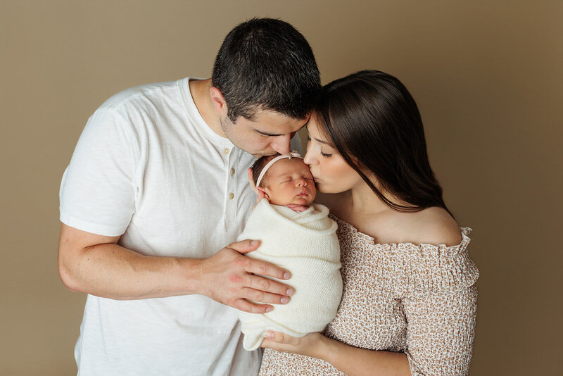 newborn boy sleeping on his tummy on a green backdrop with a tiny newborn sleepy cap in harrisburg pa newborn session
