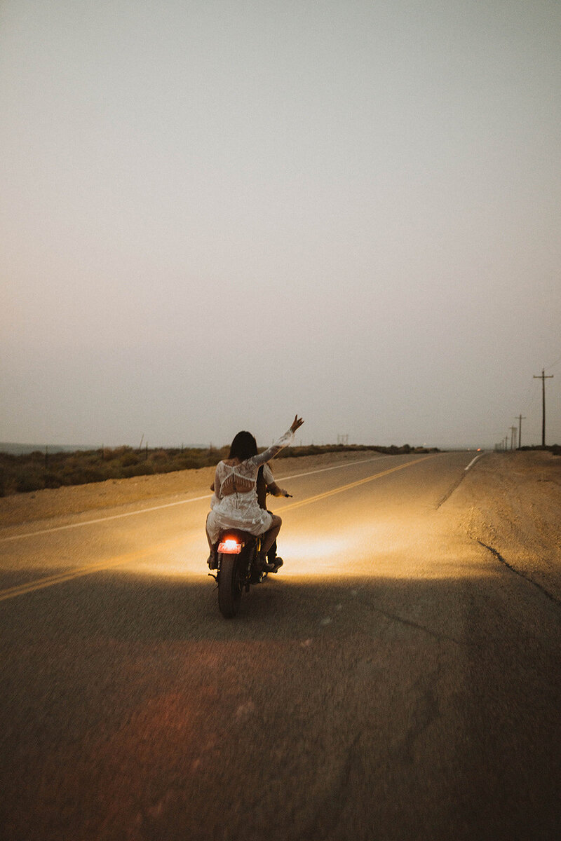 idaho elopement gallery page photo of brides riding away on a motorcycle near the snake river canyon