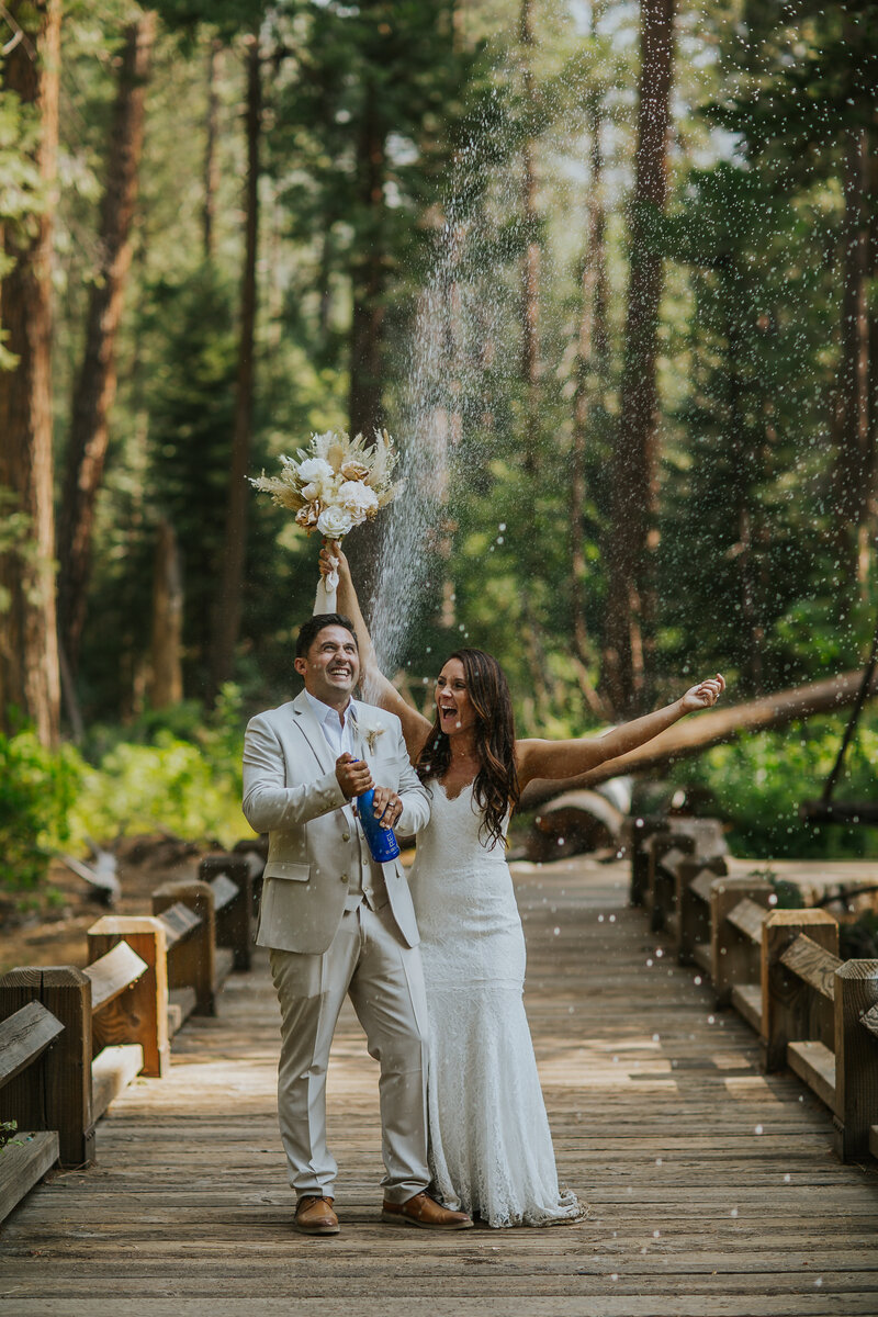 bride and groom celebrating with champagne in forest