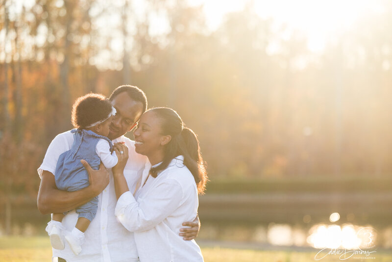 family backlit near water