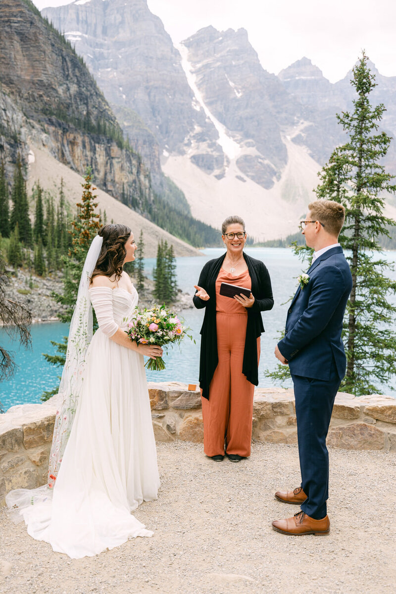 Experience the magic of a summer elopement ceremony at Moraine Lake in the Canadian Rockies. Capture the love and beauty of this stunning location on your special day.