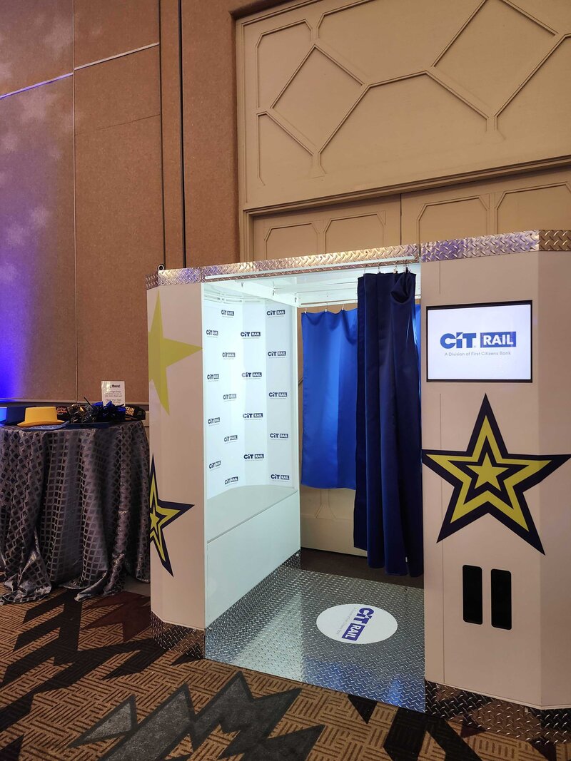 Retro-style enclosed print photo booth with branded backdrop and curtain setup at a Phoenix, Arizona corporate event, available through MISGIF Photo Booth—perfect for branded experiences and professional event photography.