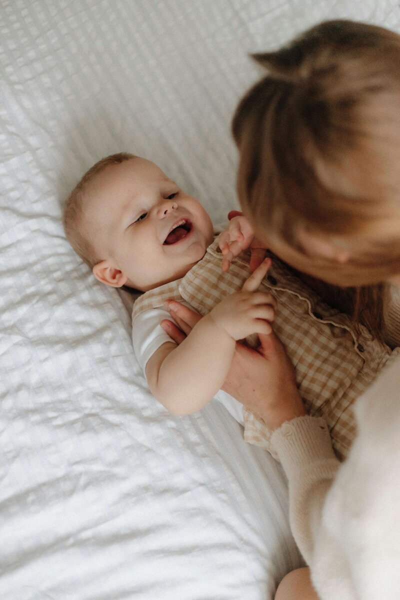 Mother tickling her toddler son