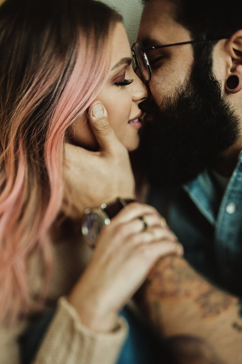 man and woman kissing pose for engagement session
