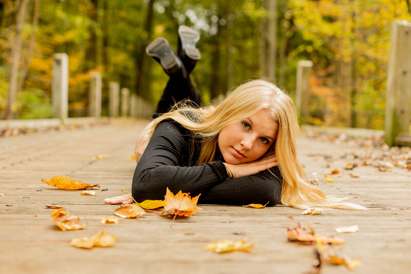 girl laying in fall leaves
