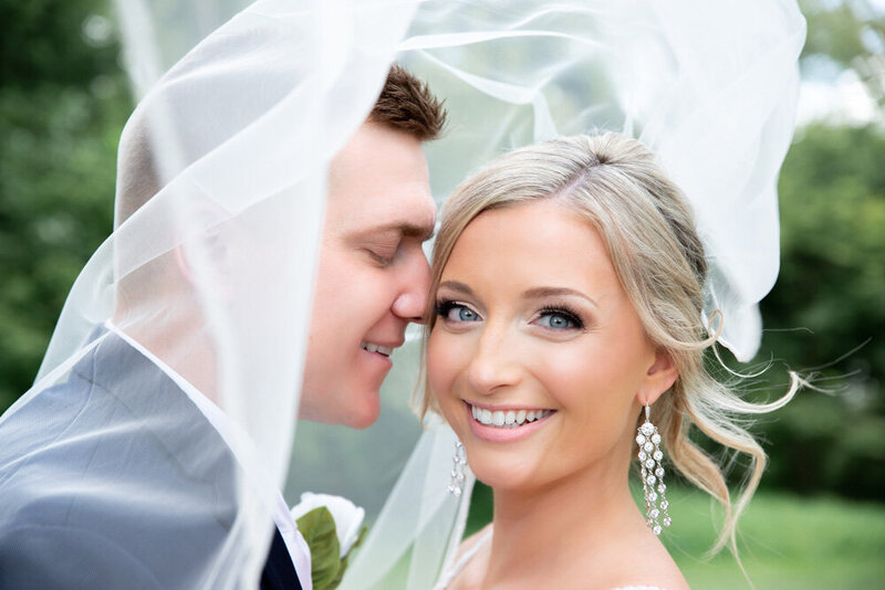 Close-up bride with long diamond earrings and groom nuzzled next to bride light and airy  bridal portraits Evalyn & Co. Photograpy